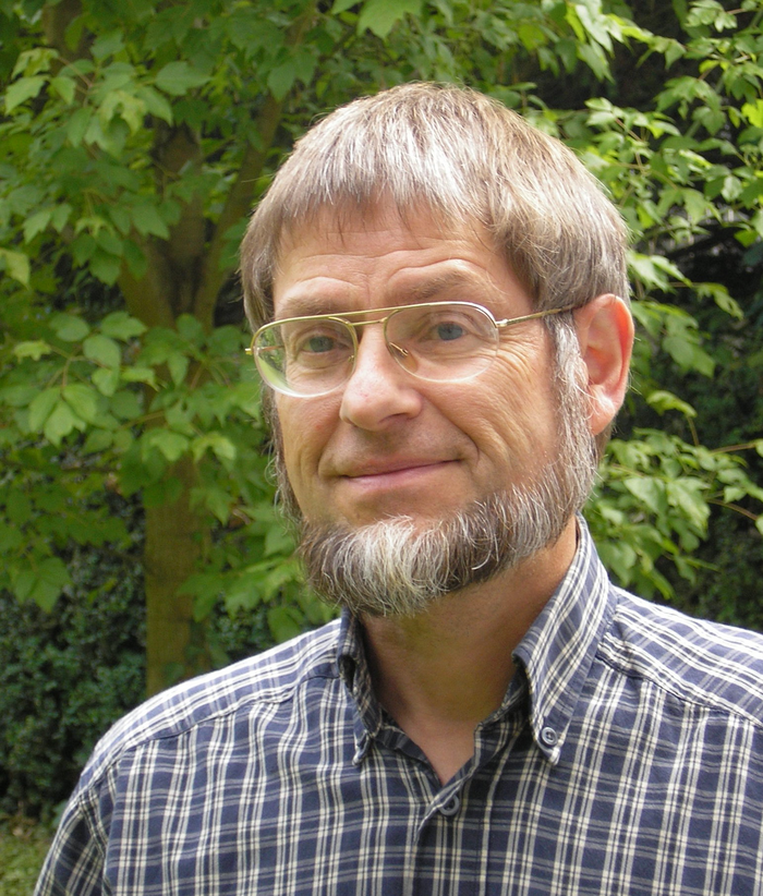 Ulrich Bastian Das Bild zeigt den Forscher Ulrich Bastian vor Bäumen.