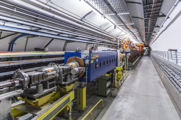 Das Bild zeigt eine Ansicht in den Tunnel, in dem sich das Super Proton Synchrotron (SPS) befindet. Das SPS ist ein Ringbeschleuniger mit einem Umfang von knapp sieben Kilometern, in dem Protonen mithilfe von Magneten auf extrem hohe Energien beschleunigt werden können.