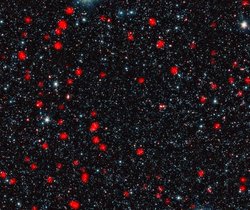 Weiter Blick in den Kosmos mit einer Vielzahl leuchtender Galaxien. Starburst-Galaxien erscheinen rot, sie sind zahlreich über den gesamten Raum verteilt.
