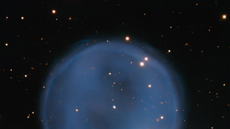 Eine kreisförmige Atmosphärenblase vor dem dunklem Sternenhintergrund des Weltalls. Am unteren rechten Rand der Blase leuchtet ein heller, kleiner Stern.