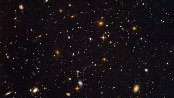 Die Aufnahme zeigt unzählige Galaxien, die sich in Form, Farbe und Größe unterscheiden, vor dunklem Hintergrund.