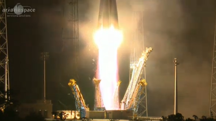 Eine Rakete steht auf einem Feuertstrahl. Haltestrukturen der Startrampe sind zur Seite weggeklappt.