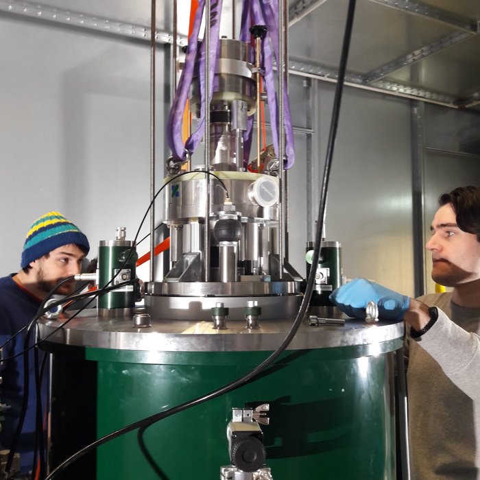 CASPEr-Experiment Zwei Forscher arbeiten an einem zylinderförmigen Instrument.