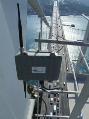 Hoch oben auf dem Brückenpfeiler einer gewaltigen Hängebrücke ist ein Kasten mit zwei Antennen befestigt, der einem WLAN-Router ähnelt, nur etwas größer ist. Auf einem Aufkleber ist lesbar: „GFZ Potsdam“ und „SOSEWIN Node“. Tief unten, im Hintergrund des Bildes, rauscht achtspurig der Kfz-Verkehr über den Bosporus.