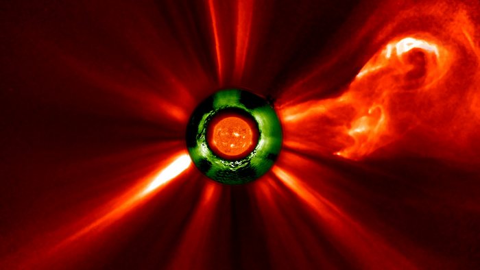 Im Zentrum des Bildes ist die Sonne als runde Scheibe abgebildet, aus der viele helle Strahlen und Bögen weit ins All hinausreichen.