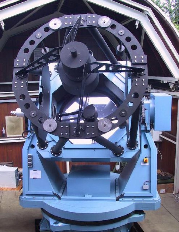 Hamburger Robotisches Teleskop Ein großes Spiegelteleskop auf einer Montierung im Inneren eines Gebäudes mit geöffnetem Dach.