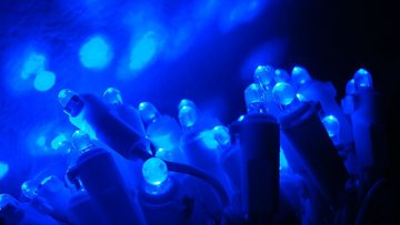 Leuchtende Blaue LEDs, die sich in einer glatten Oberfläche spiegeln.