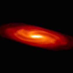 Sicht auf eine Scheibe, die in der Mitte weiß und nach außen hin orange und rot gefärbt ist. In der Scheibe ist die Spiralstruktur einer Galaxie zu erkennen.