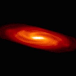 Sicht auf eine Scheibe, die in der Mitte weiß und nach außen hin orange und rot gefärbt ist. In der Scheibe ist die Spiralstruktur einer Galaxie zu erkennen.