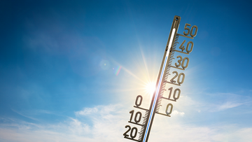 Im Hintergrund strahlt die Sonne, im Vordergrund zeigt ein Thermometer eine Temperatur von über 30 Grad Celsius an.