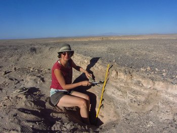 Die Wissenschaftlerin Jenny Feige bei Arbeiten mit einem Steinhammer in der Atacamawüste