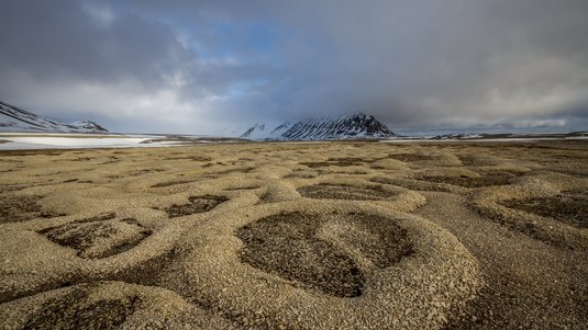 Flache Landschaft mit geometrischen Mustern im Boden.
