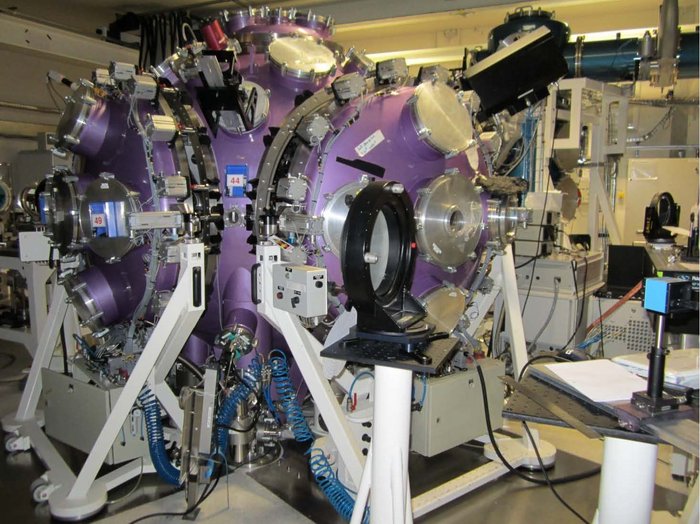 Fusionskammer mit zwei Lasern Laborraum, in der Mitte eine dickwandige Fusionskammer, in der Bor-Kerne mit Protonen verschmelzen.