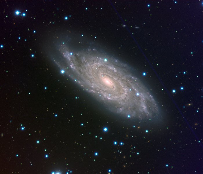 Die Spiralgalaxie NGC 6118 zeigt alle Merkmale dieses Galaxientyps Eine weiße, neblige Spirale aus Sternen auf dem schwarzen Himmelhintergrund.