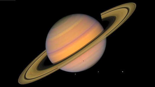 Planet Saturn, umgeben von seinen Ringen und vier kleinen Punkten, die seine Monde darstellen.