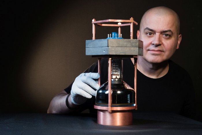 Prototyp des Neutrinodetektors Ein Wissenschaftler steht hinter einem Neutrinodetektor, der ungefähr dreißig Zentimeter groß ist.