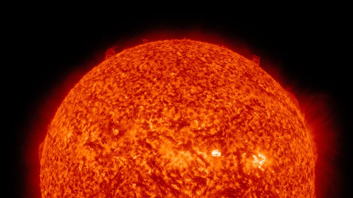 Die Sonne, aufgenommen im ultravioletten Bereich des elektromagnetischen Spektrums und rot eingefärbt. 