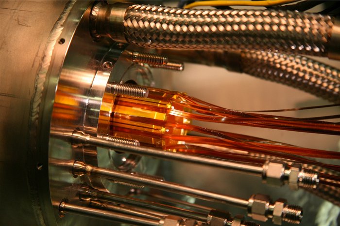 Vakuumkammer für ALPHA-Experiment Zylinderförmige Kammer aus großen Stahlteilen, in der Mitte ein Bündel orangefarbener Elektroden.