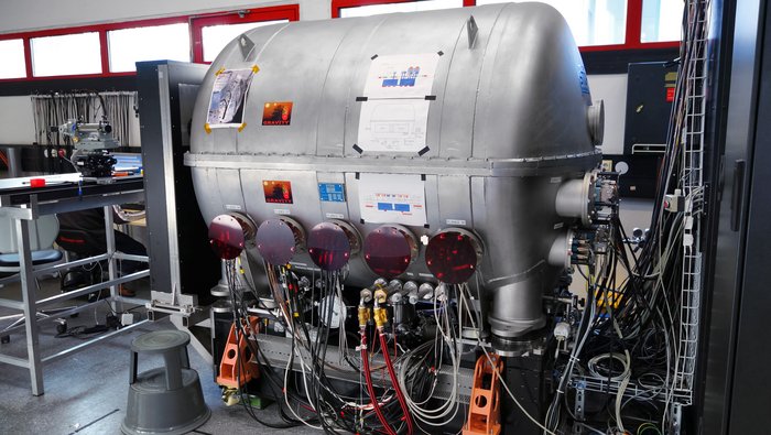 Strahlvereinigungssystem GRAVITY Das Instrument GRAVITY selbst befindet sich in einem Kryostat, einer Art ovalem Tank, an dem in der Fotografie sehr viele Kabel angeschlossen sind. Der Kryostat kühlt GRAVITY und hält Feuchtigkeit von ihm fern.