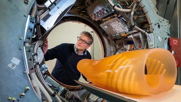 Der Physiker Franz Pfeiffer schaut in eine Maschinenröhre