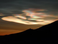 Foto, Landschaftsbild bei Dämmerung, über dem Horizont sind am Himmel ovale, hell leuchtende Bereiche zu erkennen, wie Kometenschweife am Himmel.