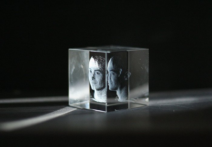 Glasblock, darin das dreidimensionale Portrait eines jungen Mannes zu sehen.