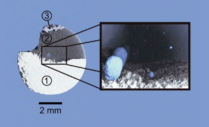 Rekonstruktion einer Laserschweißverbindung Es ist eine mondsichelförmige Struktur zu erkennen (Durchmesser 8 Milimeter), die in drei Grauschattierungen gefärbt ist. Diese geben die verschiedenen Materialdichten wieder. Auf der rechten Seite ist eine Vergrößerung eines inneren Bereiches der Mondsichel dargestellt. Dort sind blaue eierförmige Strukturen abgebildet, die Poren der Schweißnaht.