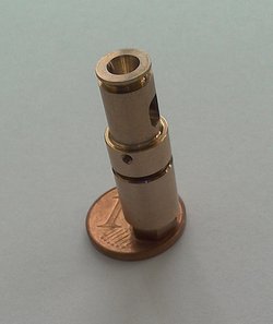 Kleiner Metallzylinder steht auf einem 1-Cent-Stück.
