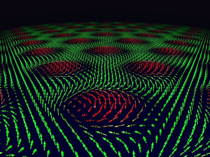 Skyrmionen Grüne und rote Pfeile zeigen in unterschiedliche Richtungen und visualisieren so die magnetischen Wirbel, die Skyrmionen.