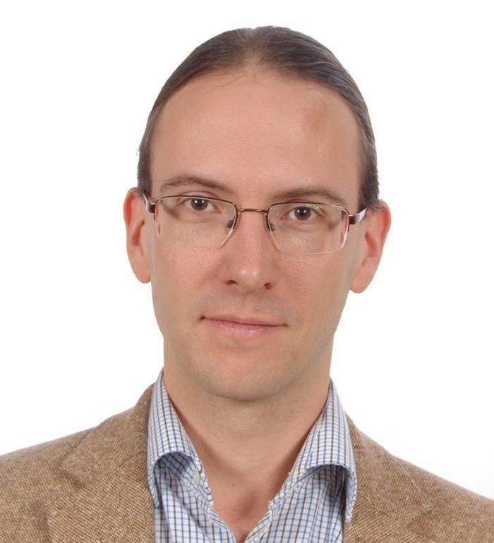 Thomas Pfeifer Thomas Pfeifer ist ein Mann Mitte 40 mit glatten braunen Haaren. Er trägt ein braunes Sakko über einem blau karierten Hemd und eine schmale Brille.
