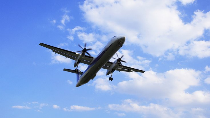 Propellerflugzeug | Bildquelle: gyro/iStock Ein großes Propellerflugzeug vom Boden aus gesehen, dahinter wolkiger Himmel