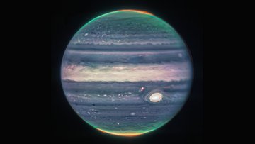 Der Planet Jupiter in blau-beigen Farbtönen. Die Polarlichter an den Polkappen sind grün und rot dargestellt. Der Hintergrund ist dunkel. 