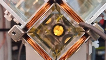Ein mit einem Draht umwickeltes quadratisches Fenster mit einem leuchtenden Punkt in der Mitte