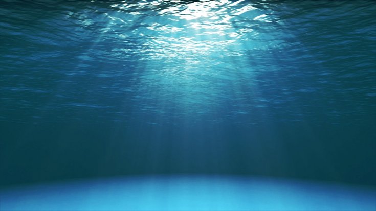 Foto von unten auf die Wasseroberfläche; Sonnenstrahlen verbreiten sich im Wasser