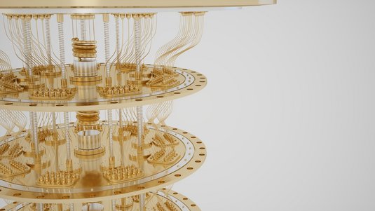 Die Abbildung zeigt eine Nahaufnahme eines Quantencomputers, bestehend aus mehreren vertikal angeordneten, kreisförmigen Ebenen aus goldfarbenem Metall. Diese Ebenen sind durch zahlreiche feine Kabel verbunden.
